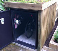 A bike locker with wooden cladding